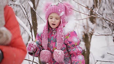 Two little girls are entangled in the snowy forest