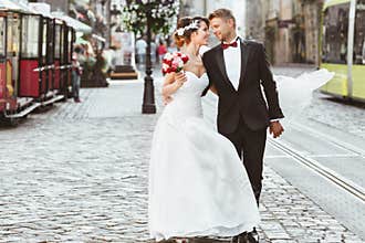 Bride and bridegroom walking across cobbled street