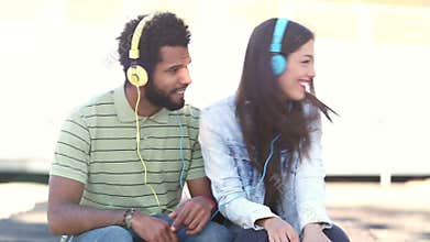 Attractive couple having fun listening to music with headphones