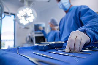 Surgeon holding surgical tool in operation theater