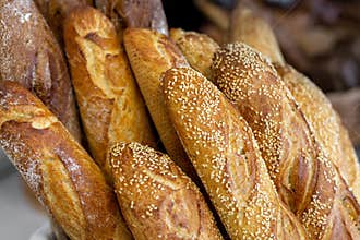 Traditional crusty French bread baguette in basket at bakery. Fresh organic pastry at local market. France cuisine background