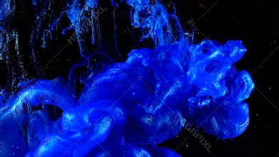 Deep blue shining glitter ink in water shooting with high speed camera. Indigo paint dropped, reacting, creating