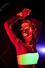 Portrait of a beautiful young girl with ultraviolet paint on her body. Pretty woman with glowing bodyart in black