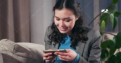 Excited businesswoman playing game on mobile phone