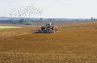 Agricultural tractor cultivating on farmland