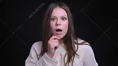Closeup shoot of young pretty brunette caucasian female being shocked and surprised with a gossip