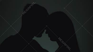 Silhouettes of man and woman. Shadows of men and women on a light background. A man and a woman touch each other with their faces.