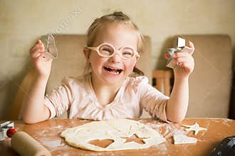 Happy girl with Down syndrome bakes cookies
