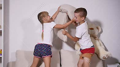 Children playing on the couch with pilows, slow motion