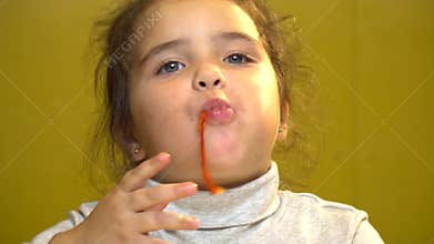 Close up of the little girl is eating pizza with her hands. she has a dirty mouth.