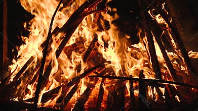 Ultra slow motion shot of fire flames and glowing ashes on black background