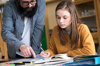 Young teacher helping his student in chemistry class. Education, Tutoring concept.