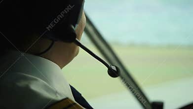 Happy pilot talking to controller, navigating airliner while moving on runway