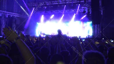 Many people waving hands together, enjoying music at rock band concert, slow-mo