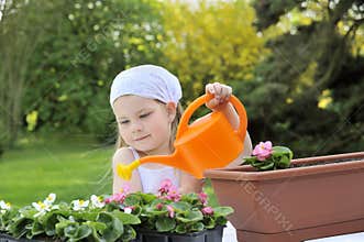 Little girl watering flowers