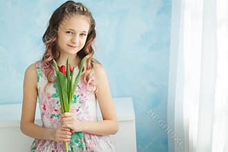 Adorable smiling teenager girl with tulips