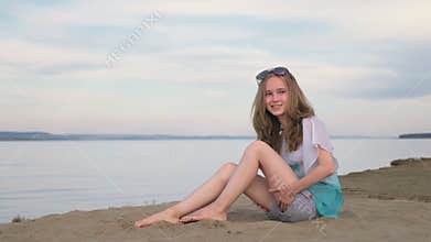 One beautiful teenage girl with brown hair outside on a beautiful summer day.