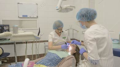 Woman at dentist clinic gets dental treatment to fill a cavity in a tooth. Dental restoration and composite material