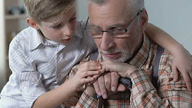 Caring grandson comforting sad grandfather, hugging with love, family support