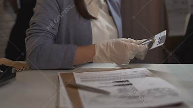 Detective worker measuring bullet size and entering data in crime scene report