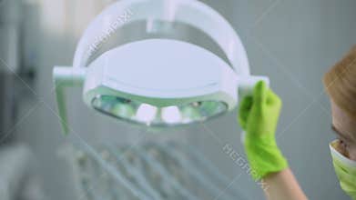 Female surgeon adjusting lighting before operation, plastic surgery, cosmetology