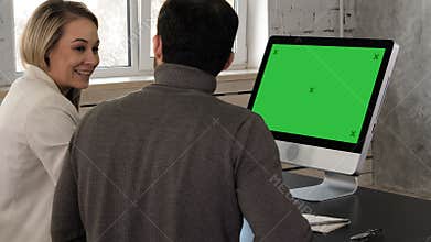 Two young businessman having a meeting at office looking in monitor. Green Screen Mock-up Display.