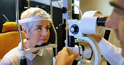 Optometrist examining patient eyes with slit lamp 4k