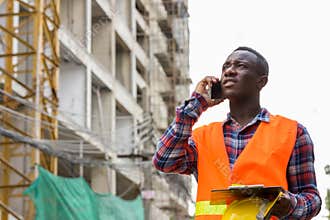 Thoughtful young black African man construction worker talking o
