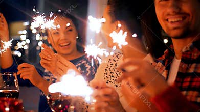Friends with sparklers at home christmas dinner