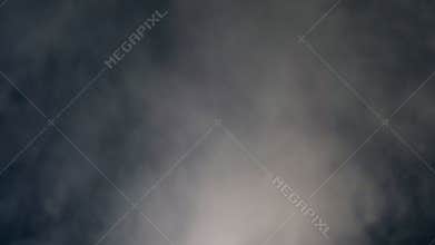 Darkness is getting filled with dissolving puffs of mist, fog, isolated smoke