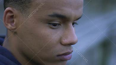 Depressed african-american guy thinking about his life, lonely sitting outdoor
