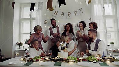 A senior man with multigeneration family celebrating birthday on indoor party.