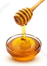 Honey stick and bowl of pouring honey isolated on white background with clipping path