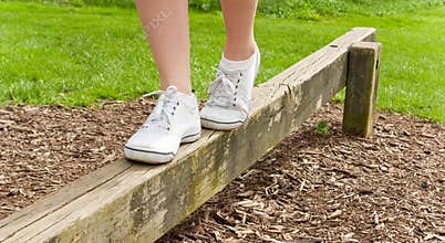Feet balancing on a balance beam.