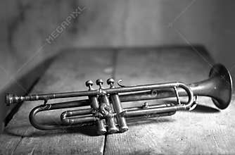 An ancient trumpet on an old wooden table
