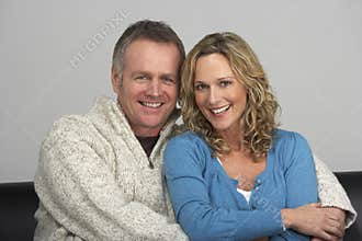 Middle Aged Couple Sitting On Sofa