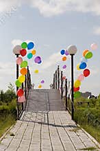 Colorful helium baloons at bridge opposite blue sky