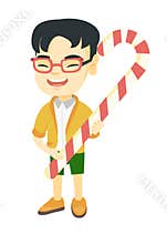 Asian little boy holding christmas candy cane.