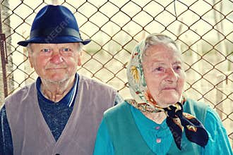 Elderly couple sitting together on a country road