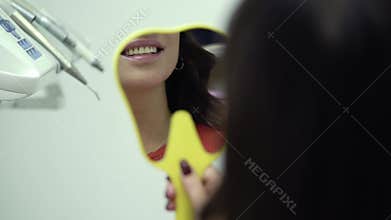 Woman looking at the mirror in dental clinic