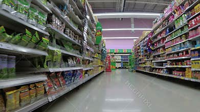 Shelves with goods in supermarket. Grocery shopping from view of a shopping cart. Thailand.