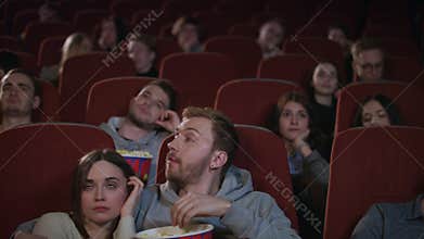 Bored audience leaving cinema while session in slow motion. Uninteresting film