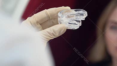 Preparation for teeth whitening for a young girl, puts gel on whitening trays.