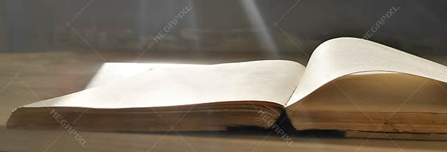 On the open book fall rays of sunlight from the window. Light. Sunlight. book lighting. Open workbook