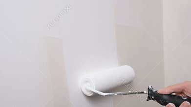 Roller painting wall with white paint. Painting out a bare wall with a paint roller with white paint. 4K resolution