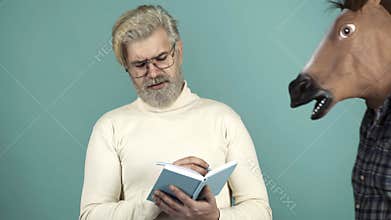 Funny Writer Thinker Concept. Funny and Crazy Idea. The Curious Man with Horse Head Mask. Humorous video. Concept Non