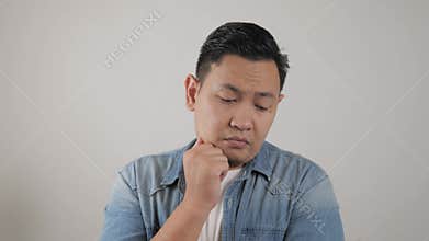 Asian man thinking something seriously, sad worried contemplation gesture