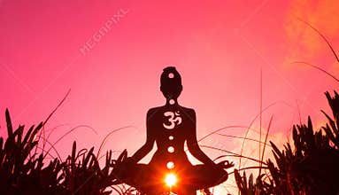 Silhouette of a person doing yoga with the root chakra symbol