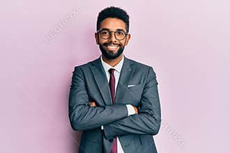 Handsome hispanic business man with beard wearing business suit and tie happy face smiling with crossed arms looking at the camera
