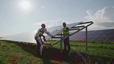 Male engineers installing solar panels together